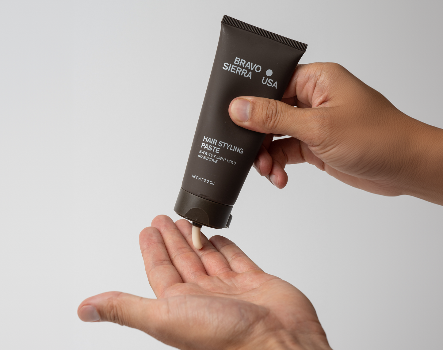 Hair styling paste by Bravo Sierra in a brown tube squeezed into a palm on Tampa Home & Garden Store