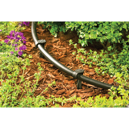 Orbit Irrigation 1/2in drip tubing anchor stake with black tubing in mulch garden bed on Tampa Home & Garden Store