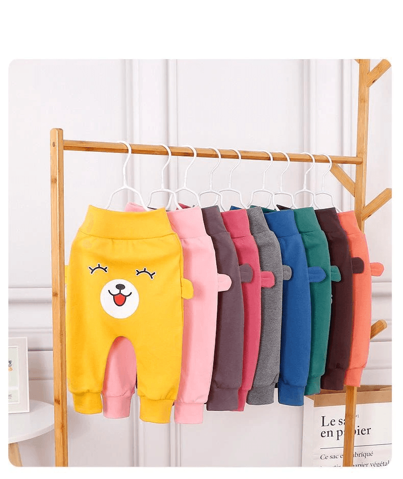 Stevvex baby pants with bear face and ears, assorted colors on a wooden rack on Tampa Home & Garden Store