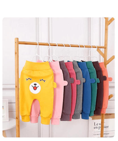 Stevvex baby pants with bear face and ears, assorted colors on a wooden rack on Tampa Home & Garden Store