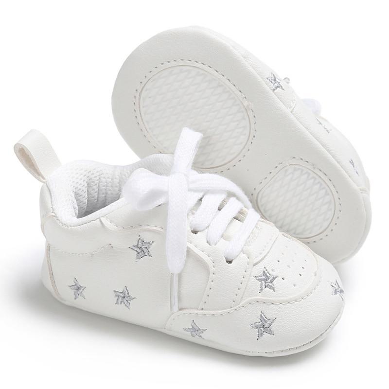 White PU leather newborn baby sneakers with lace-up closure and silver star accents, pair on Tampa Home & Garden Store