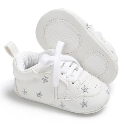 White PU leather newborn baby sneakers with lace-up closure and silver star accents, pair on Tampa Home & Garden Store
