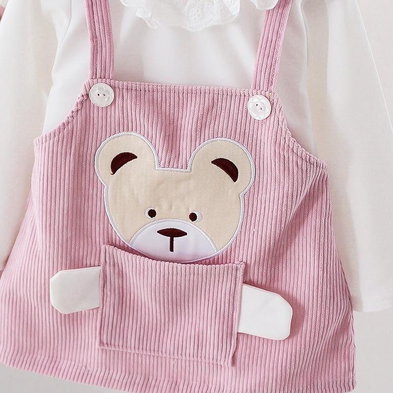 Stevvex pink corduroy dress with bear face pocket and strap buttons over white top on Tampa Home & Garden Store