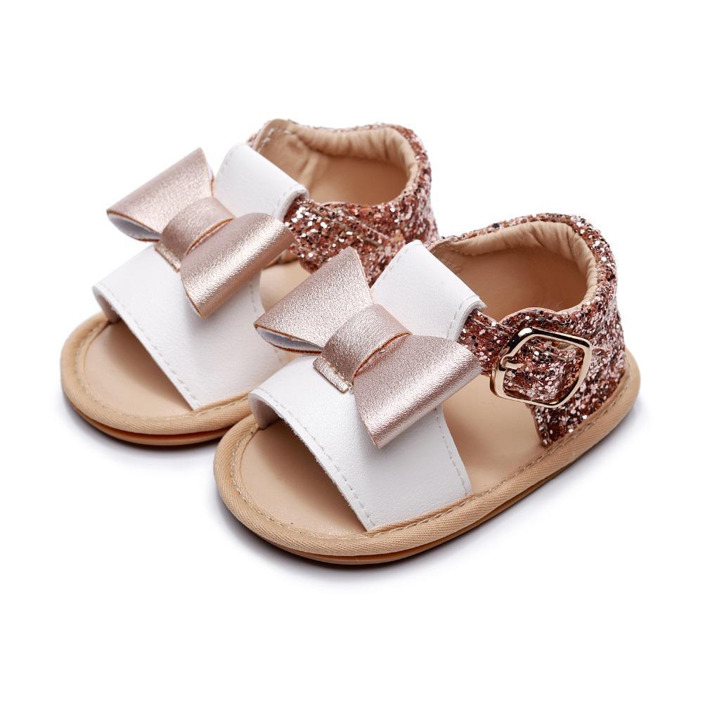 Pair of baby girl sandals with white PU leather straps, rose-gold glitter back strap and bowknot on Tampa Home & Garden Store