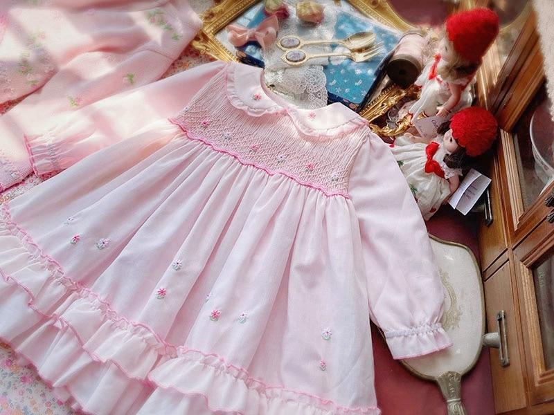 Pink handmade baby girl dress with smocked bodice, subtle floral embroidery and ruffled hem on Tampa Home & Garden Store