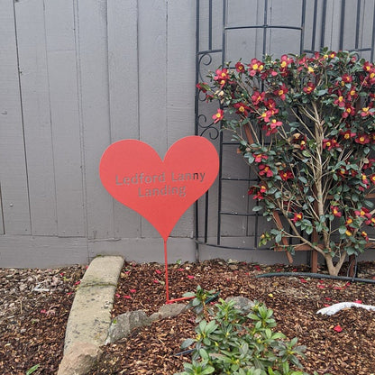 Heart garden stake rust-colored metal by Rustica Ornamentals in a garden scene on Tampa Home & Garden Store