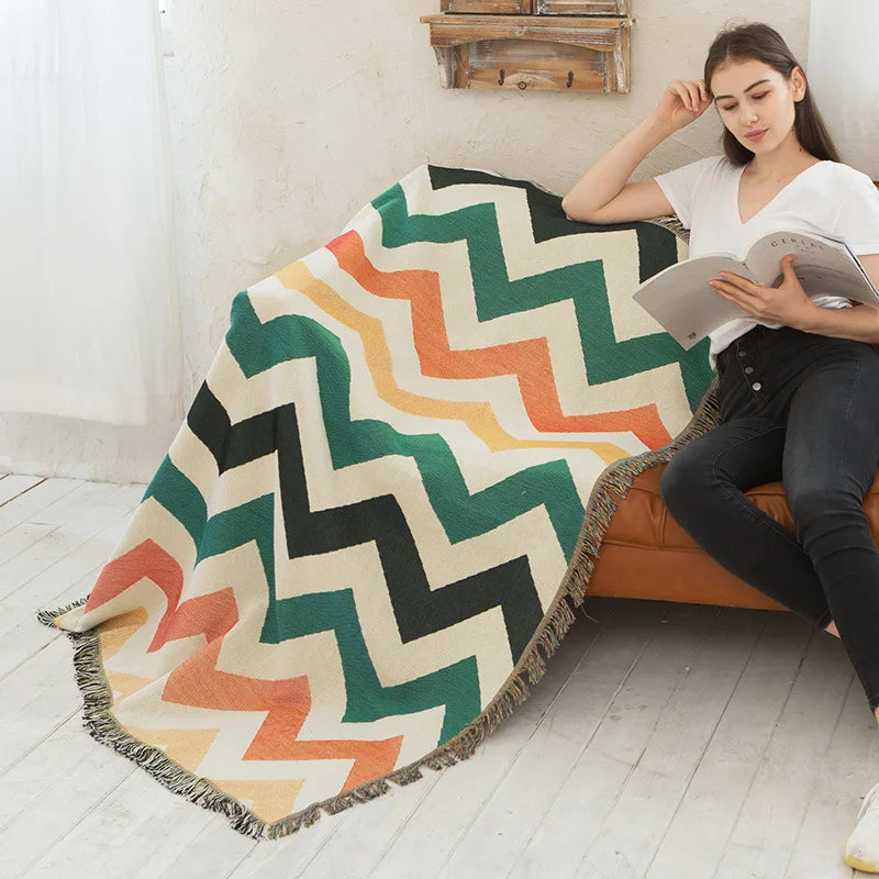 DecorBites knitted Nordic plaid blanket with chevron pattern and fringe draped over sofa on Tampa Home & Garden Store