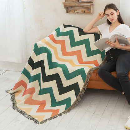 DecorBites knitted Nordic plaid blanket with chevron pattern and fringe draped over sofa on Tampa Home & Garden Store