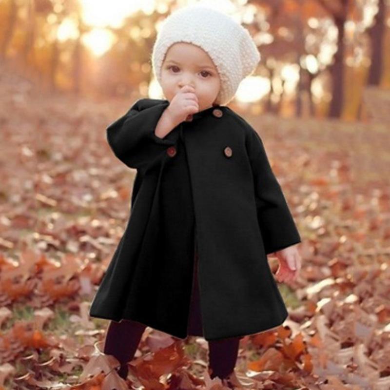 Baby girl Stevvex woolen long coat in black with brown buttons; white knit hat in autumn park on Tampa Home & Garden Store