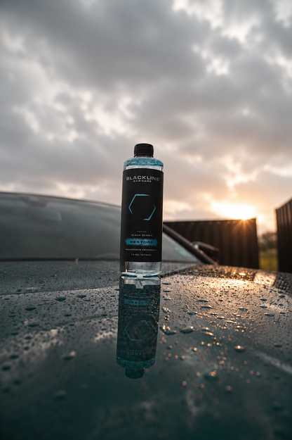 BLACKLINE Restore microfiber detergent bottle on wet car hood with blue accents at sunset on Tampa Home & Garden Store