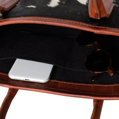 Huntley Equestrian hair-on-hide cow leather tote with brown strap and edges; phone inside on Tampa Home & Garden Store