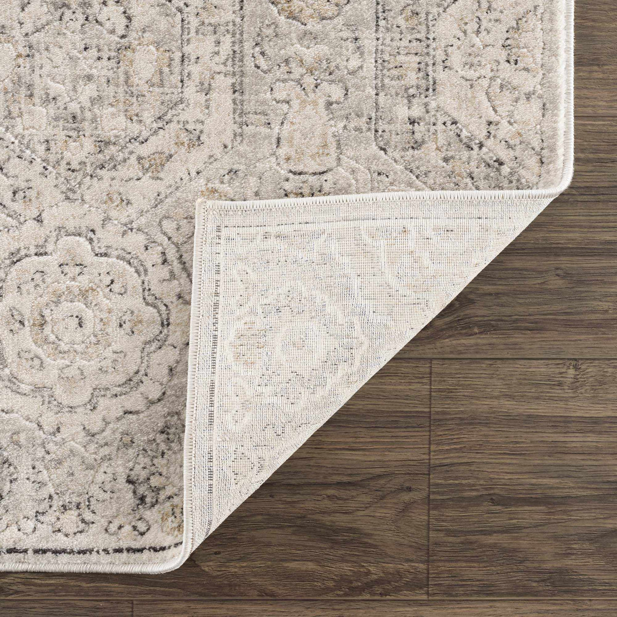 Parkerfield Area Rug by Boutique Rugs; beige vintage pattern with fringe on wood floor on Tampa Home & Garden Store