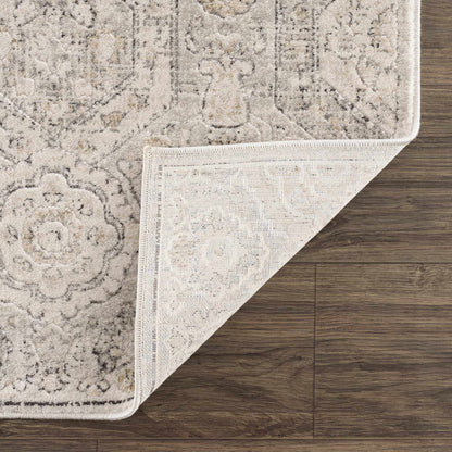 Parkerfield Area Rug by Boutique Rugs; beige vintage pattern with fringe on wood floor on Tampa Home & Garden Store