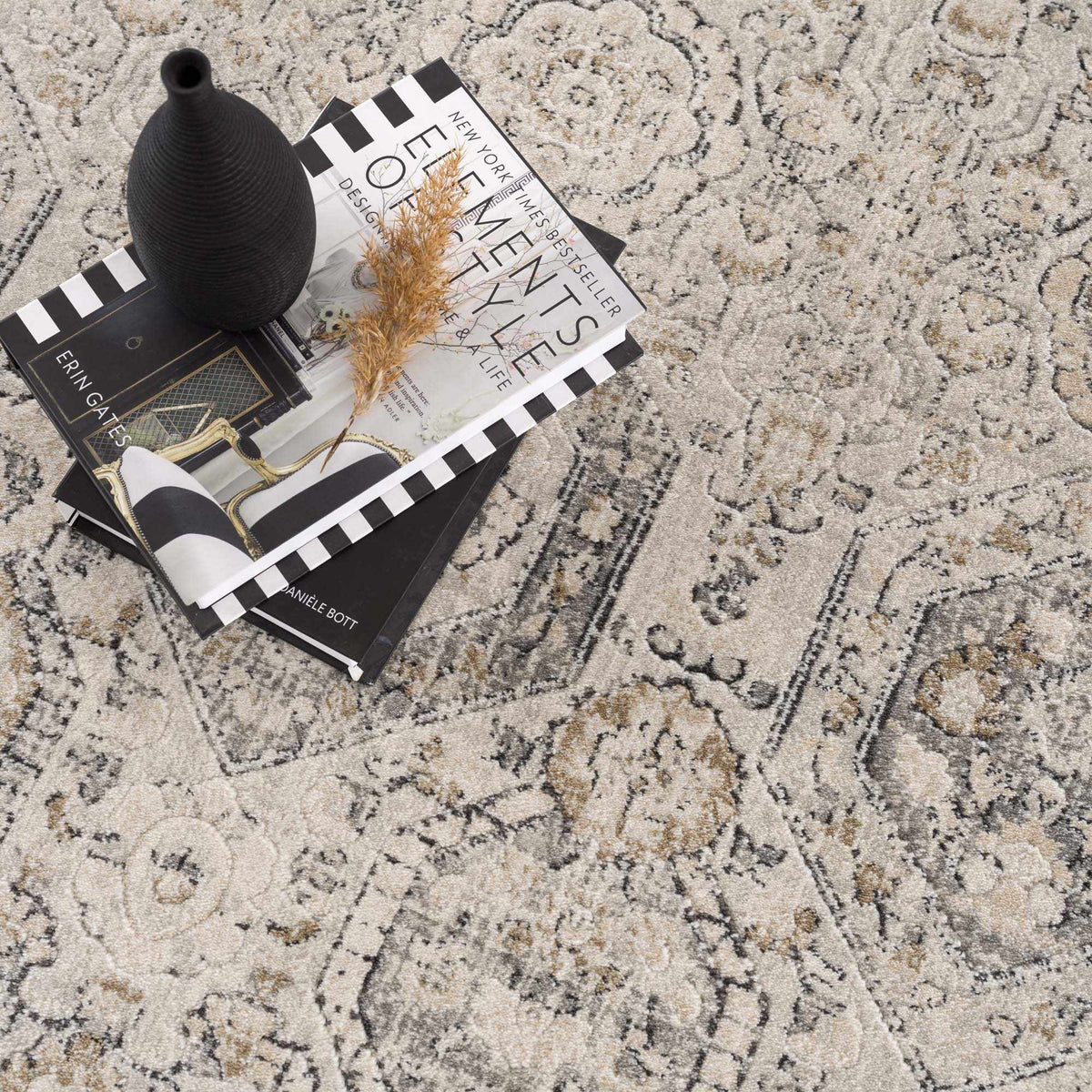 Parkerfield Area Rug by Boutique Rugs, beige gray ornate pattern with black vase and magazines on Tampa Home & Garden Store