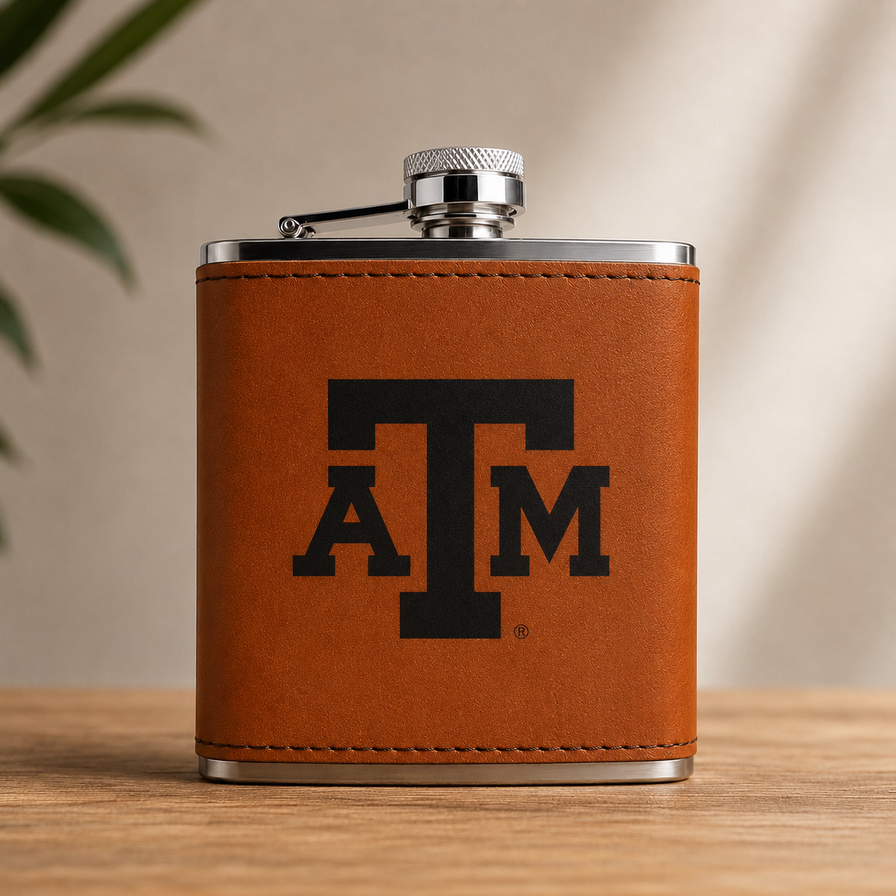Texas A&M Leather Flask with brown stitched leather wrap and silver cap, black TAM logo on Tampa Home & Garden Store