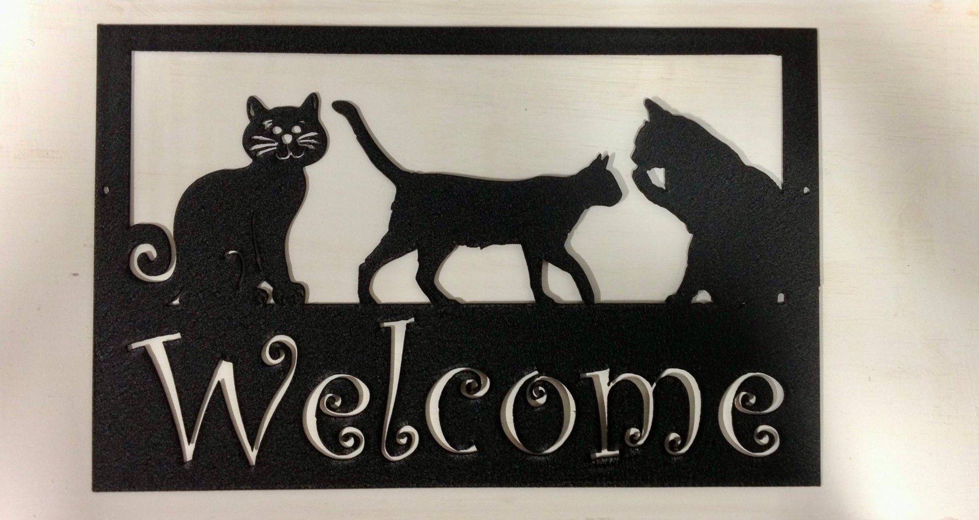 Custom metal pet sign with three silhouettes and a white Welcome script on black frame on Tampa Home & Garden Store