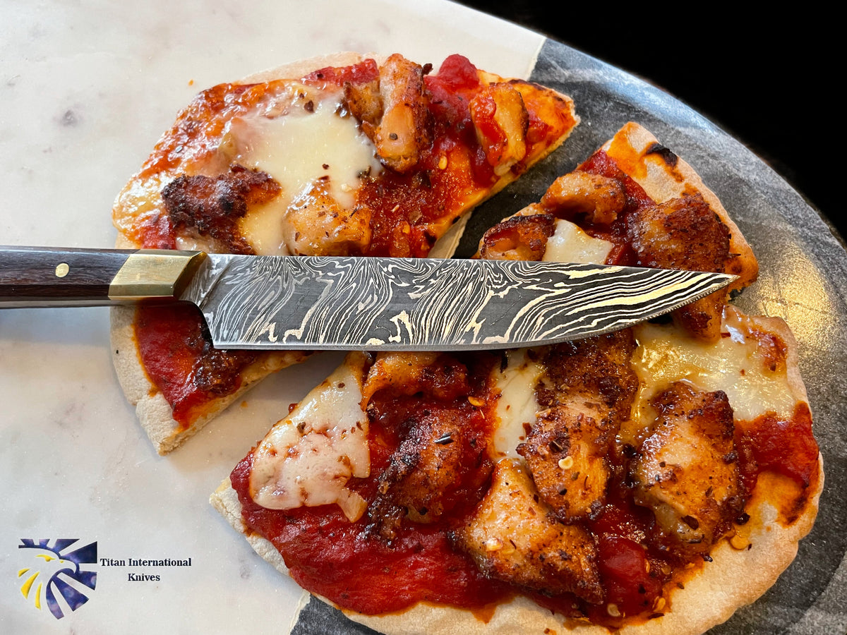 Damascus steel steak knife by Titan International Knives with wood handle on pizza on Tampa Home & Garden Store