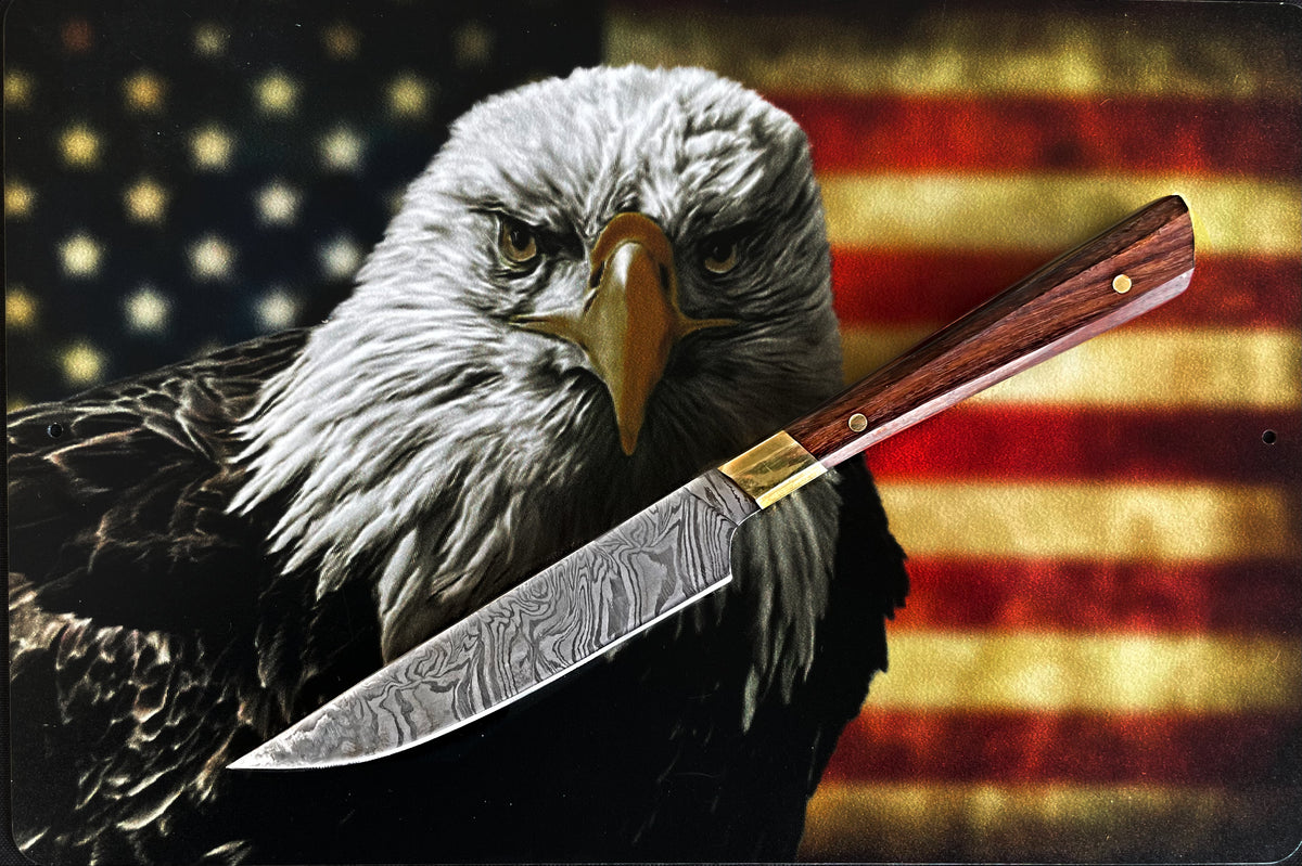 Damascus steel steak knife with wood handle and brass rivets over US flag backdrop on Tampa Home & Garden Store