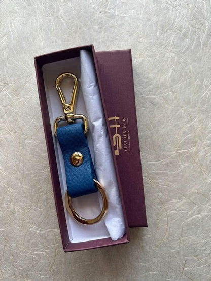 Sophia full-grain leather key ring with blue strap and gold hardware in a purple gift box on Tampa Home & Garden Store