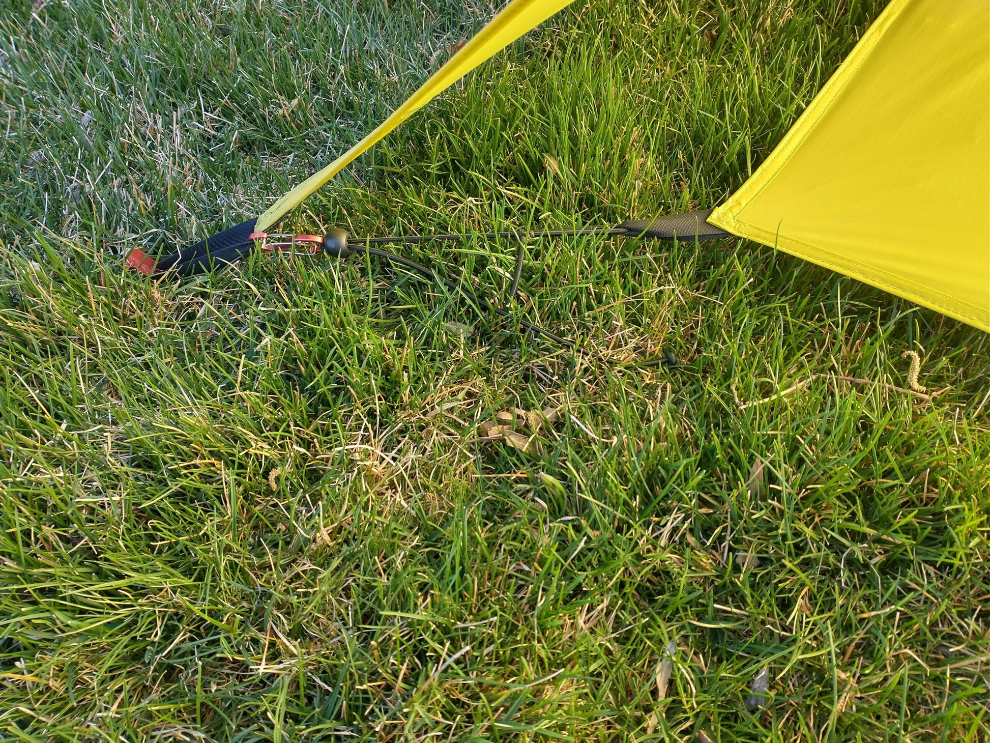 Trekker Elite Tarp Tent by River Country Gear, yellow tarp with guy lines on grass on Tampa Home & Garden Store