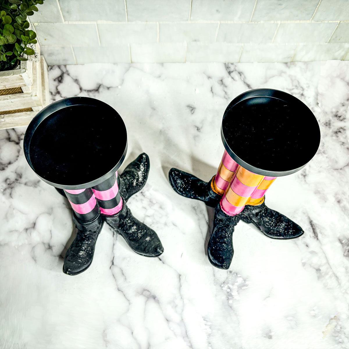 Wicked Witch Candle Holders with striped stockings and black glitter boots on marble floor on Tampa Home & Garden Store