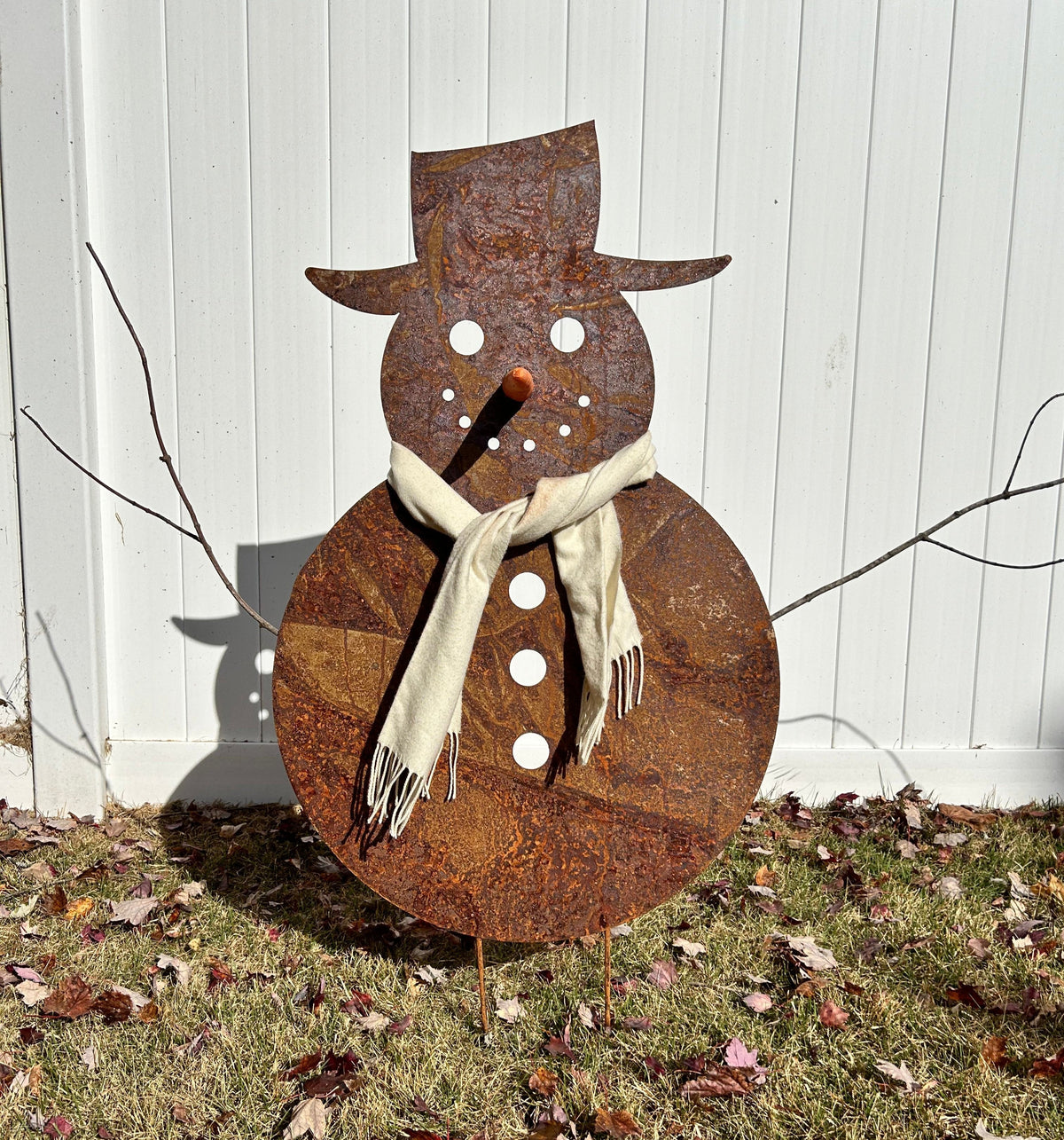 Large outdoor snowman metal sculpture with rust finish, scarf, orange carrot nose and white button accents on Tampa Home & Garden Store