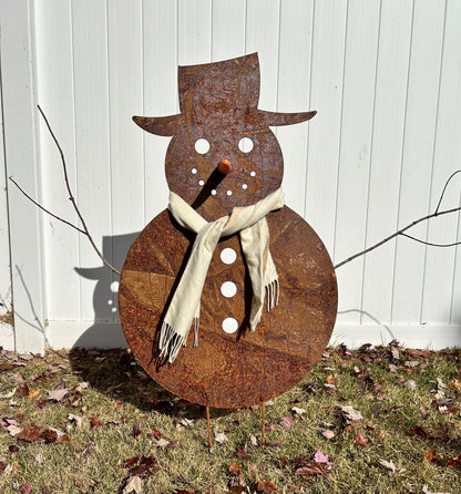 Large outdoor snowman metal sculpture with rust finish, scarf, orange carrot nose and white button accents on Tampa Home & Garden Store