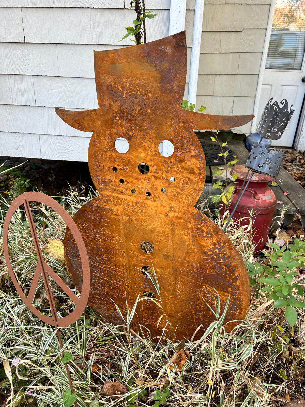 Large outdoor snowman metal sculpture with rust patina and cutout eyes, holes, garden decor on Tampa Home & Garden Store