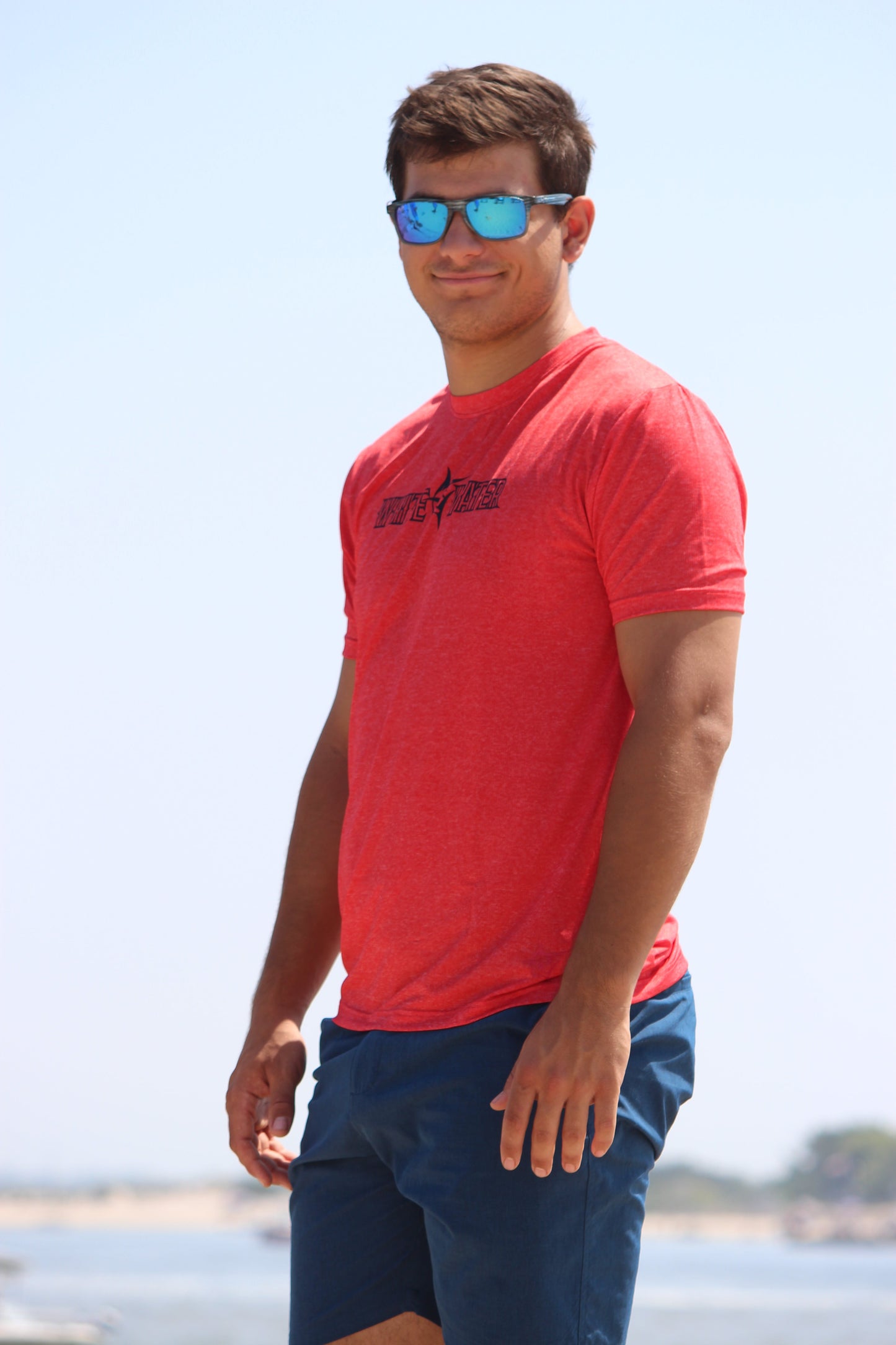 Bimini Primary Performance Tee red tee by White Water Life at beach with blue sunglasses on Tampa Home & Garden Store