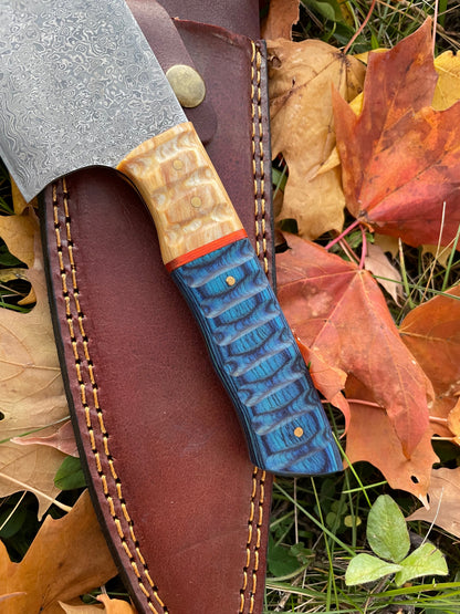 Damascus steel custom chef knife TK-043 with blue layered handle beside brown leather sheath on Tampa Home & Garden Store