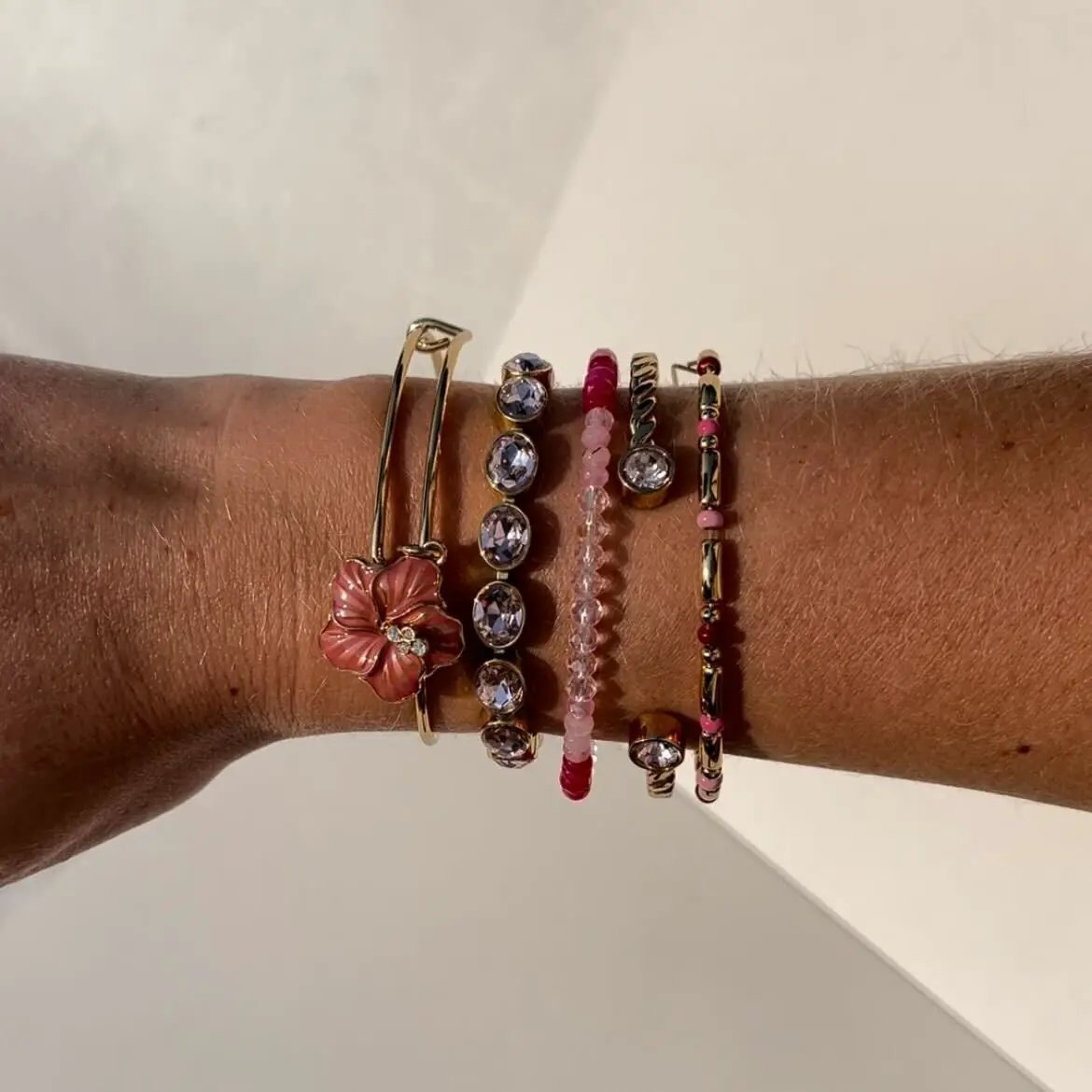 Hibiscus Charm Bangle by ALEX AND ANI with pink flower charm; stacked pink bead bracelets on wrist on Tampa Home & Garden Store