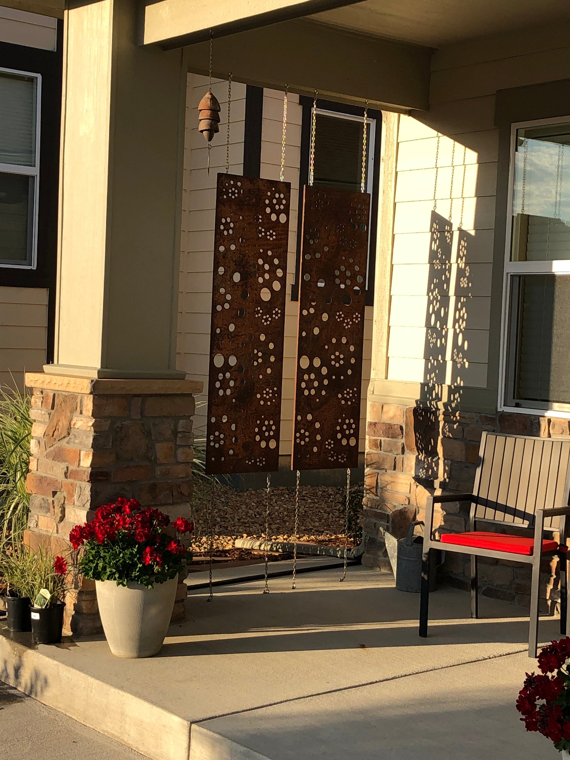 Rust metal privacy screen panels with circular cutouts, 46 in tall, hanging on porch on Tampa Home & Garden Store