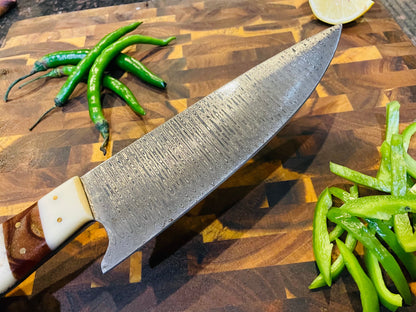 Damascus steel knife from Titan International K with ivory Arylic handle on wooden cutting board on Tampa Home & Garden Store