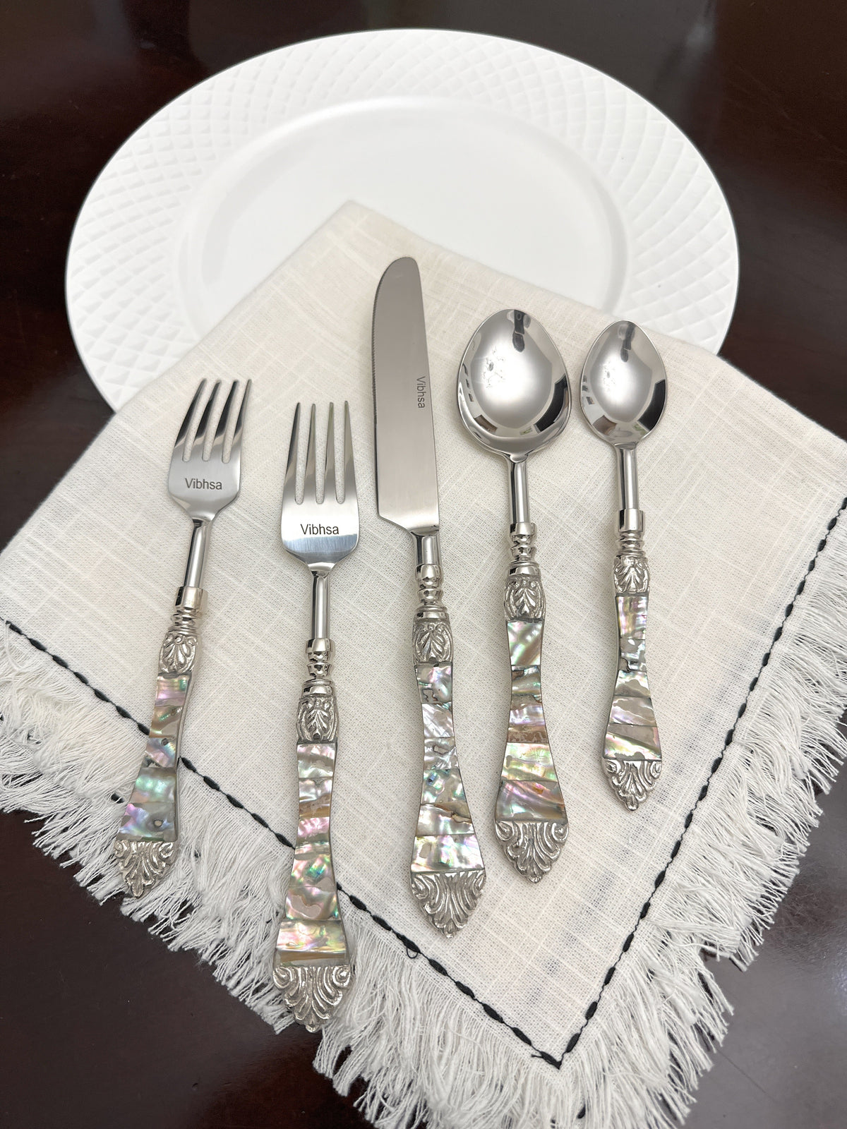 Vibhsa 20-piece stainless steel flatware set with Seawork handles on a beige napkin on Tampa Home & Garden Store