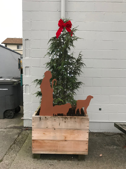 Nativity Scene Outdoor display with orange silhouettes around a wooden planter by Rustica on Tampa Home & Garden Store
