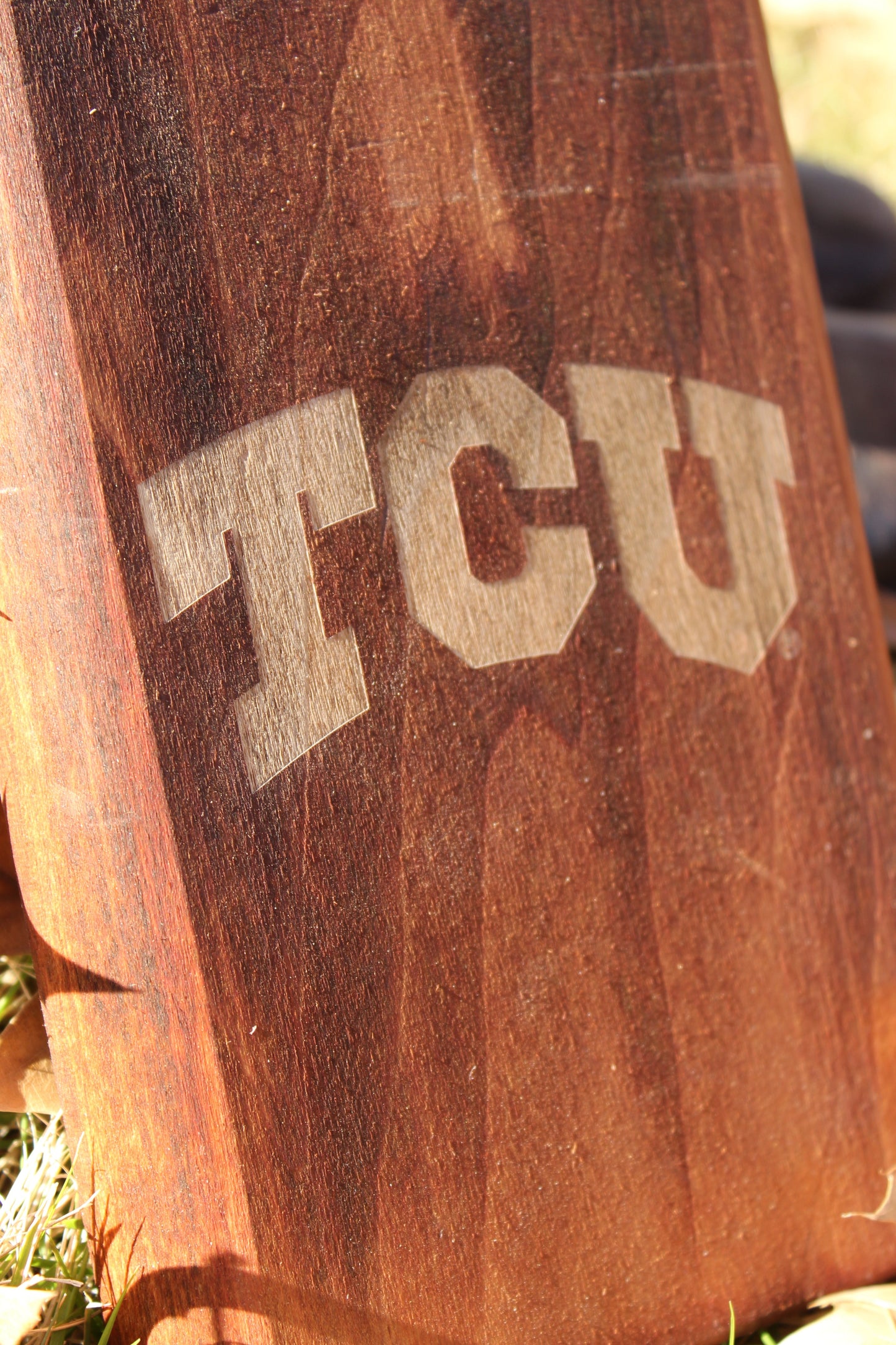 TCU boot jack on a warm brown wooden post with large tan TCU lettering on Tampa Home & Garden Store