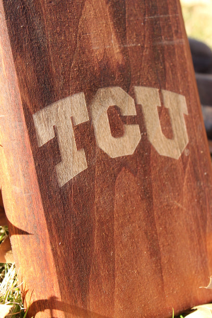 TCU boot jack on a warm brown wooden post with large tan TCU lettering on Tampa Home & Garden Store