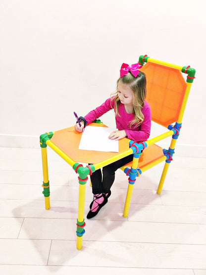 TubeLox Deluxe Set construction toy; bright yellow legs, orange seat, kid drawing at desk with 3 storage bags on Tampa Home & Garden Store