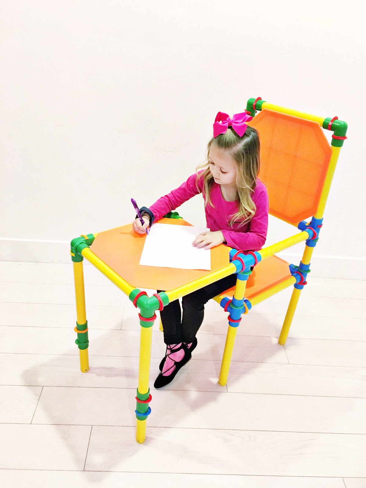 TubeLox Deluxe Set STEM desk for kids yellow frame, orange top, green/blue joints; child drawing on Tampa Home & Garden Store