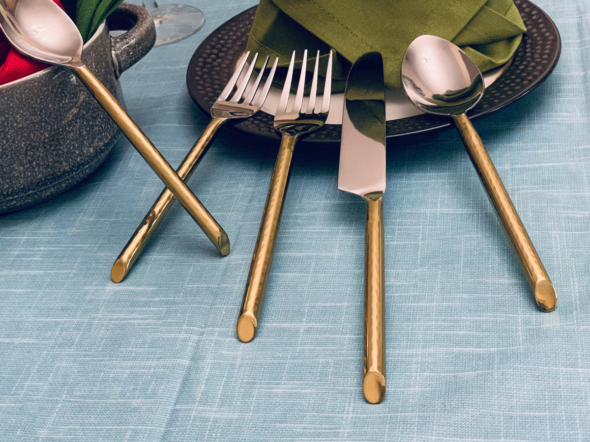 Vibhsa 30-piece gold-tone flatware set with polished heads beside plate and napkin on Tampa Home & Garden Store