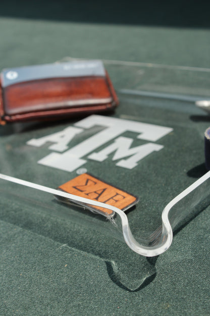 Texas A&M acrylic tray by Ryan's Woodworking, clear TAMU logo tray on green surface on Tampa Home & Garden Store