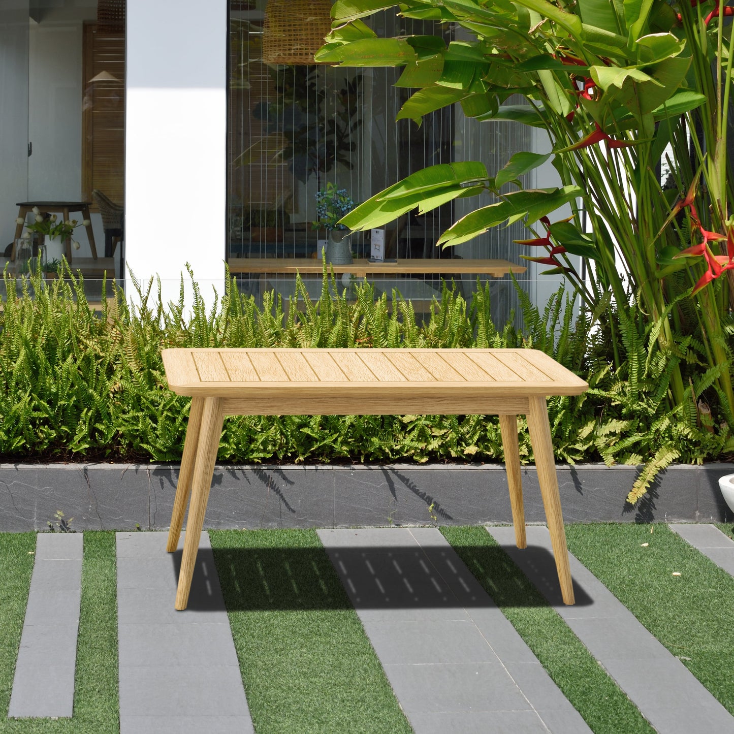Eve FSC Teak Outdoor Conversation Set teak table on a modern patio with lush greenery on Tampa Home & Garden Store