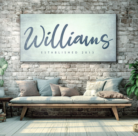 Family name sign canvas with navy Williams script on distressed backdrop against stone wall on Tampa Home & Garden Store