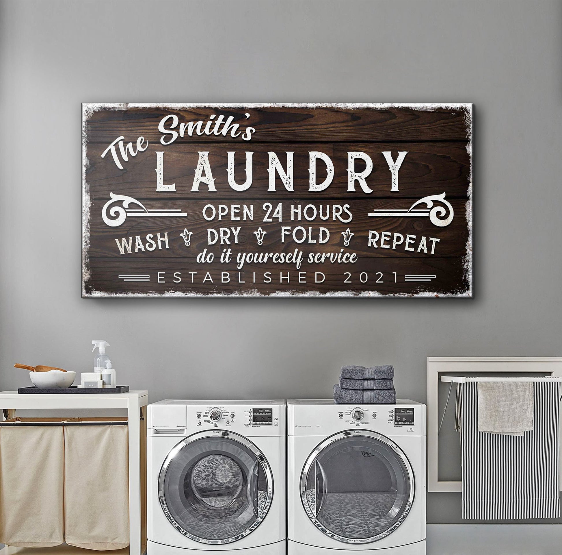 Canvas sign with dark wood grain border reading The Smith's LAUNDRY OPEN 24 HOURS on Tampa Home & Garden Store
