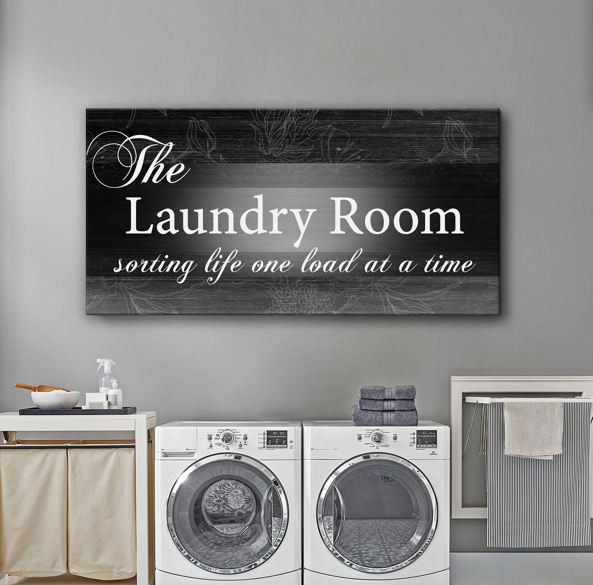 Canvas sign The Laundry Room Sign II on black wood-grain panel with white script and floral accents on Tampa Home & Garden Store