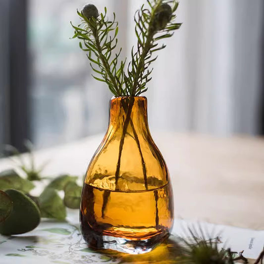 Amber handblown glass bottle vase by RusticReach with greenery stems on Tampa Home & Garden Store