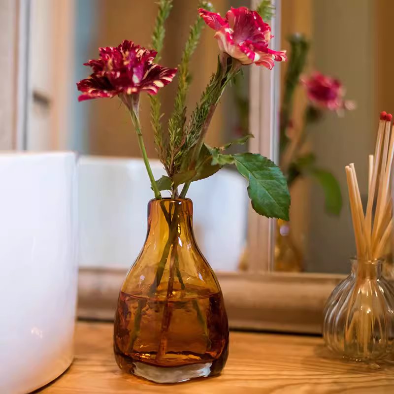 Amber handblown glass vase by RusticReach, amber-toned bottle holding floral stems on Tampa Home & Garden Store
