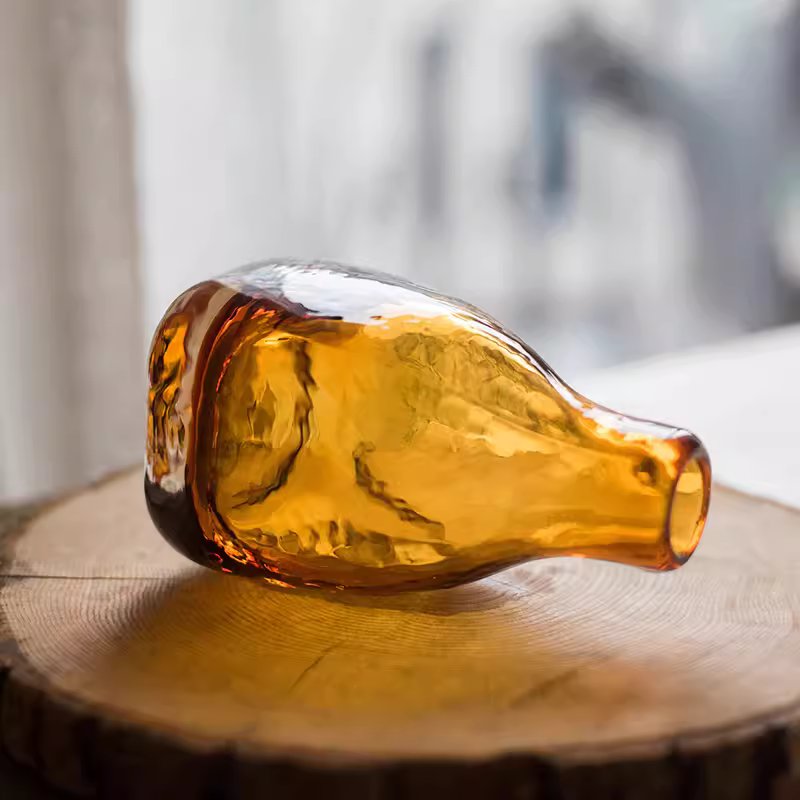 Amber handblown glass bottle vase by RusticReach, warm amber hue on a wooden surface on Tampa Home & Garden Store