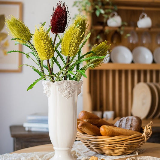 Faux Banksia Integrifolia flower arrangement in a white vase with yellow and burgundy blooms on Tampa Home & Garden Store