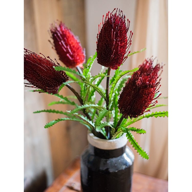 Faux Banksia flower 28-inch burgundy spikes with green leaves in a dark vase RusticReach on Tampa Home & Garden Store